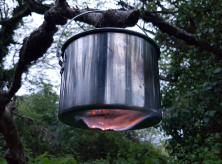 Burning Exogel Camping Stove Gel Fuel applied to the underside of a hanging billy can in the woods, and so heating the pot without need of a stove.