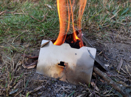 The Stealth Stove burning some twigs, and ready to be used as a wind-deflecting pot stand.