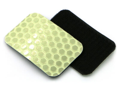 Two Cyflect Patches, showing the glow-in-the-dark / retroreflective surface, and the hook patch surface, on a plain white background.