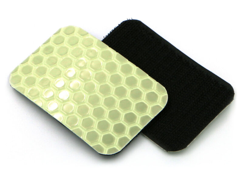 Two Cyflect Patches, showing the glow-in-the-dark / retroreflective surface, and the hook patch surface, on a plain white background.