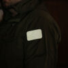The glinting Cyflect Patch, attached to shoulder of a military jacket.