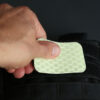 Applying the Cyflect Patch to a tactical black rucksack, using the hook and loop attachment.