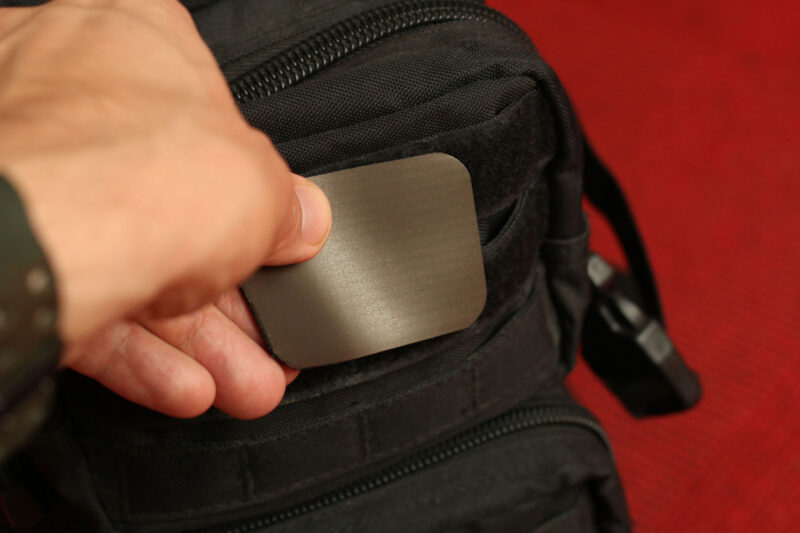 The Mag Patch being affixed with hook and loop to a tactical black backpack.