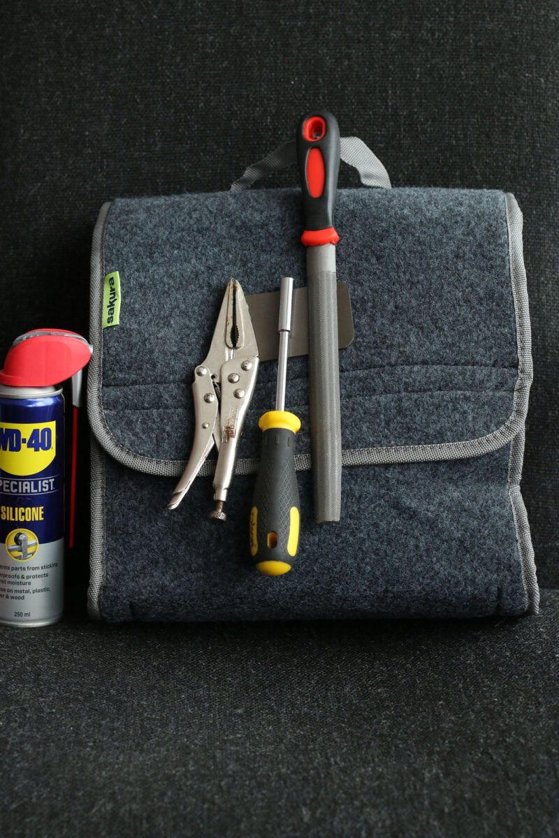 The Mag Patch affixed with hook and loop to a car boot storage bag, with various automotive tools attached magnetically.