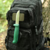 The Mag Patch affixed with hook and loop to a tactical rucksack, with a bushcraft knife magnetically attached during a woodland camp.