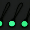 Three Magnetags brightly glowing green against a dimly-lit surface.