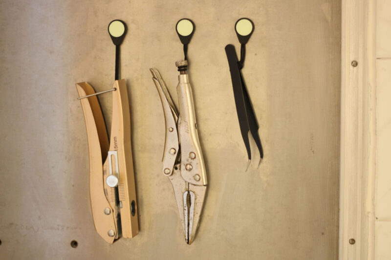 Three tools, each hanging from a Magnetag, which are magnetically attached to a steel surface.